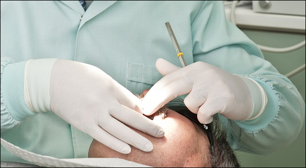 Cirujano haciendo una cirugia dental en la boca de un paciente